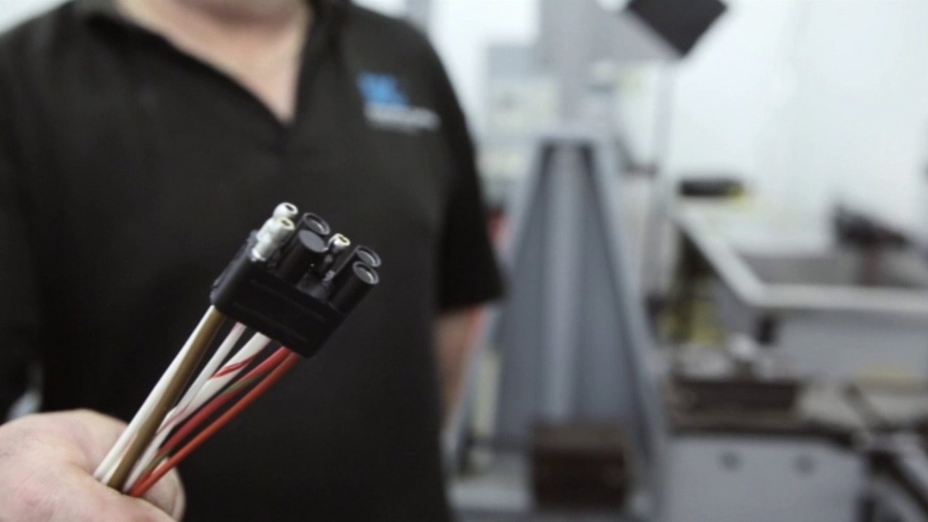 Man holding wires and term with blurred SIC logo on shirt